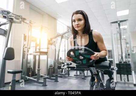 Premium Photo  The girl does exercises with equipment a woman in the gym  for circular training is engaged in loops of tpx under the supervision of a  trainer female teaches client