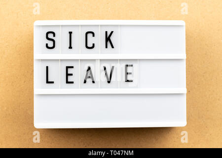 Light box with word sick leave on wood background Stock Photo