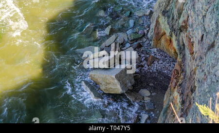 Big and small rocks found on the shoreline of the cliff in Paldiski with the waves splashing from the sea and seen the cliff from above Stock Photo