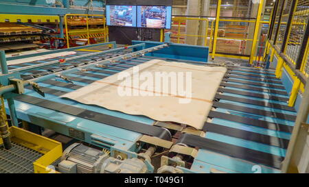 Thin sheets of woods on the machine to processed into plywoods in the sawmill factory Stock Photo