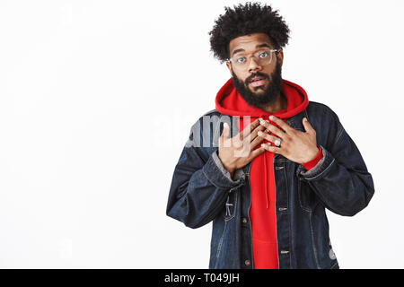 Waist-up shot of surprised guy being amazed he was named holding hands on chest questioned and delighted, explaining himself as standing in front of Stock Photo