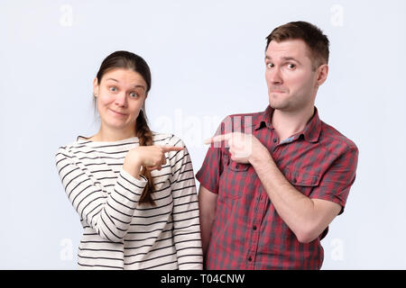 Blaming each other. Beautiful young european couple pointing each othe Stock Photo