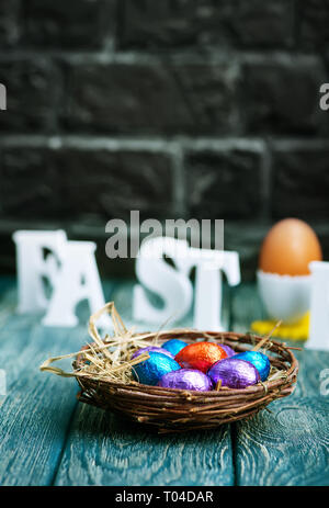 color easter eggs in nest and on a table Stock Photo