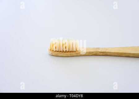 Wooden bamboo toothbrush close-up on grey background Stock Photo