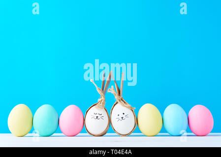 Easter eggs with painted faces in row on blue background Stock Photo