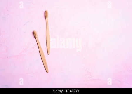 Two wooden toothbrushes on pastel pink background Stock Photo