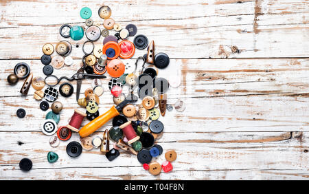 Spools of threads and buttons on wooden table.Scissor, sewing buttons and thread