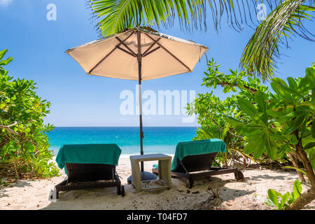 Chairs and umbrella in paradise beach. Stock Photo