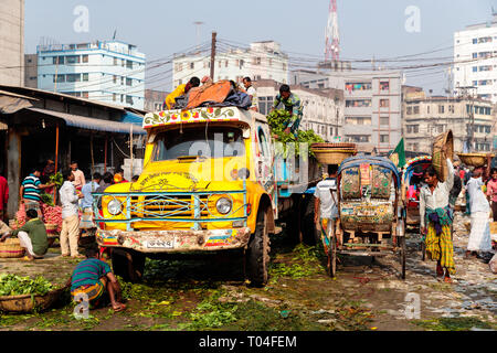 Colorful fruit market with van and rickshaw and people transporting goods in the streets of Dhaka, Bangladesh Stock Photo