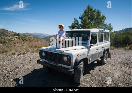 Rural Andalucia. Spain. 06/10/2016. Little girl admiring the view while sitting on front spare tyre on a bonnet hood in 4x4 terrain vehicle. Stock Photo