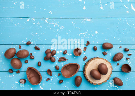 Delicious chocolate Easter bunny, eggs and sweets on rustic background Stock Photo