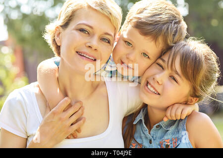 portrait of a family outdoors. mom with children in the summer. Mother and kids Stock Photo