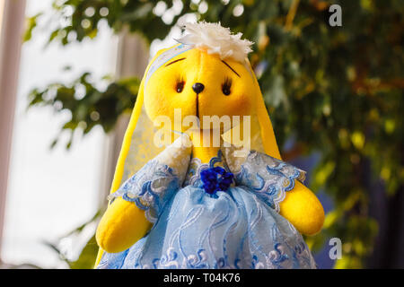 Soft toy yellow hare close-up. Handmade doll Stock Photo