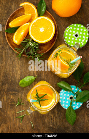 Cold summer drink set. Refreshing summer berry Lemonade, lemon mint Tea and orange Lemonade with rosemary. Top view flat lay background. Stock Photo