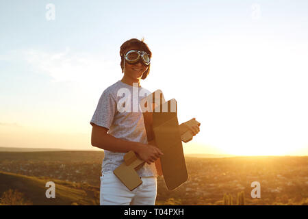 Teenager with toy airplane on nature at sunset Stock Photo