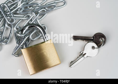 Padlock, chain and keys on a white background. Security abstract concept. Copy space in top right corner. Stock Photo