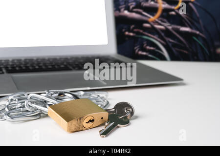 Padlock, chain and keys with laptop computer with bunch of cables in the background. Cyber security abstract concept. Stock Photo