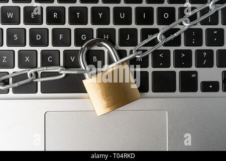 Padlock with chain on a laptop computer keyboard. Cyber security abstract concept. Stock Photo