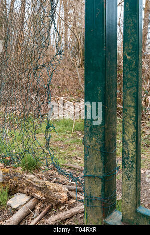 Security breach into wire mesh fence through big hole Stock Photo