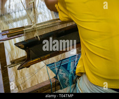 Worker weaving textile on loom at cooperative workshop, Luang Prabang, Laos, Asia Stock Photo