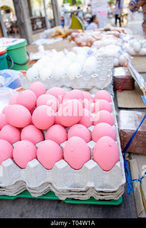 Chicken eggs painted pink for sale on market stall, Phuket, Thailand. Stock Photo