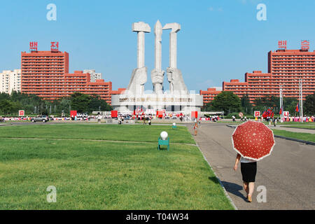 Pyongyang, North Korea - 26 July 2014. Monument to founding of the state party in DPRK capital featuring hammer, Sickle and calligraphy brush. Stock Photo