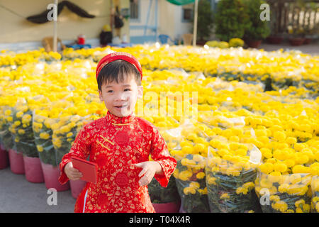 Portrait of a Asian boy on traditional festival costume. Cute little Vietnamese boy in ao dai dress smiling. Tet holiday. Lunar New Year Vietnam Stock Photo