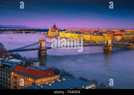 Famous European touristic travel location. Amazing cityscape panorama with spectacular Chain bridge and Parliament building at colorful sunset, Budape Stock Photo