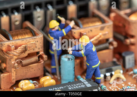 Miniature people maintenance electronic device component. Stock Photo
