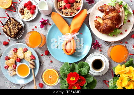 Breakfast food table. Festive brunch set, meal variety with pancakes, croissant, juice, granola,  fresh berries and  fruits. Top view with copy space. Stock Photo