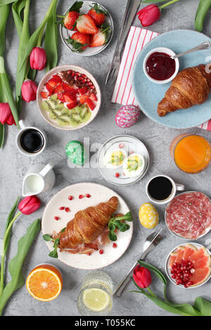 Breakfast food table. Festive brunch set, meal variety with flowers. Top view. Stock Photo