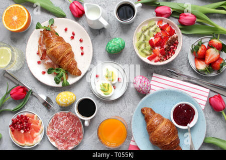 Breakfast food table. Festive brunch set, meal variety with flowers. Top view. Stock Photo