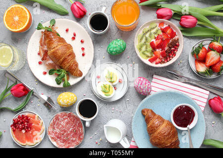 Breakfast food table. Festive brunch set, meal variety with flowers. Top view. Stock Photo