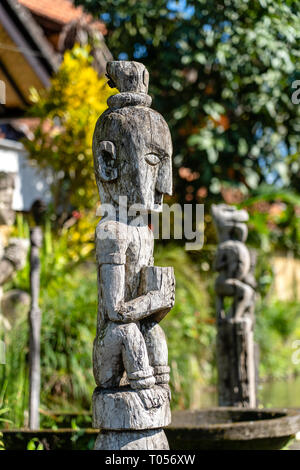 Balinese ancient wooden statue on street in Ubud, island Bali, Indonesia. These figures of the gods protect the house from evil spirits. Close up Stock Photo