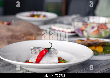 Many different dishes, fish, salads served on the restaurant table. Concept banquet, buffet, party, trying new menu Stock Photo