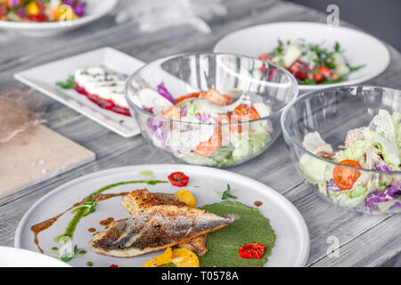 Many different dishes, fish, salads served on the restaurant table. Concept banquet, buffet, party, trying new menu Stock Photo