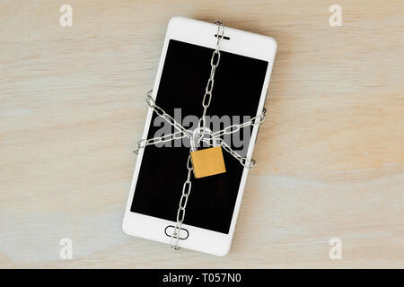 Smartphone locked with chain and padlock - Concept of mobile security and data privacy Stock Photo