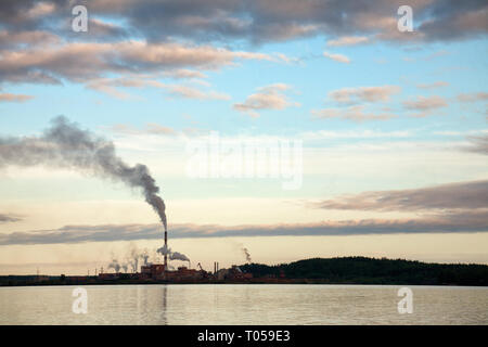 Smoking pipes of Pulp-and-paper factory on a lake in Russia - Carbon Dioxide emissions water pollution environmental issues concept Stock Photo
