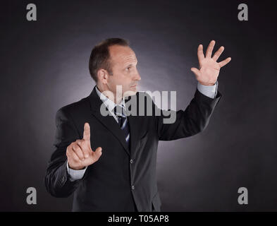 businessman pointing at a virtual point. photo on black background Stock Photo