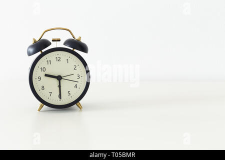 alarm clock standing on a table with room for text Stock Photo