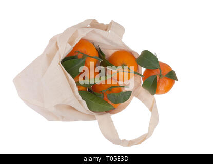 Fresh picked oranges in reusable, recyclable fabric shopping tote bag, isolated on white. For environmentally friendly, green consumers. Stock Photo