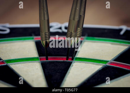 dart board with three darts in the triple twenty area. Stock Photo