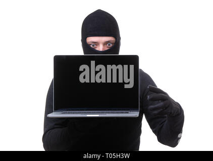 Hacker man in black mask with laptop with blank screen in hands. Stock Photo