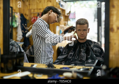 Man is cutting his hair in asian barbershop Stock Photo