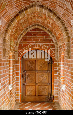 Wooden door in a brick tunnel, close up Stock Photo