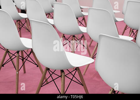 Conference white chairs in business room, rows of white plastic comfortable seats in empty corporate presentation meeting office, detail, selective fo Stock Photo