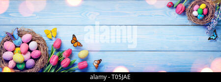 Easter - Tulips And Nests With Eggs On Blue Wooden Plank Stock Photo