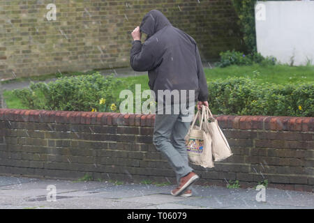 London, UK. 17th Mar, 2019.  A man with shopping bags walking in London as hailstones starts falling  Credit: Dinendra Haria/Alamy Live News Credit: Dinendra Haria/Alamy Live News