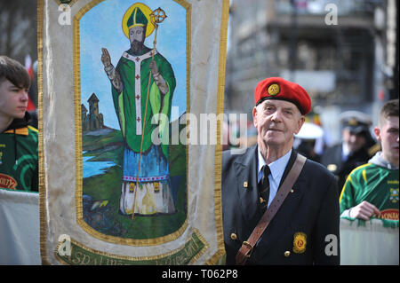 London, UK. 17th Mar, 2019. A man carrying a religious banner depicting St Patrick as a bishop on the annual St Patrick’s day parade in Central London, England, United Kingdom.  St Patrick was of Romano-British parentage and was taken as a slave to Ireland in the 5th century, where he experienced a religious conversion. He founded the archiepiscopal see of Armagh in about 454AD. The 17th of March is the supposed date of St Patrick’s death in 461AD. Credit: Michael Preston/Alamy Live News Stock Photo