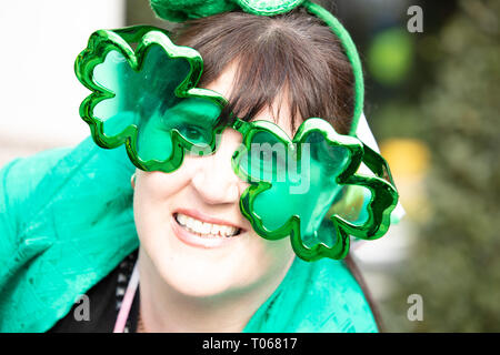 London, UK. 17th March, 2019. Spectator with shamrock sunglasses at the St Patrick's Day Parade London near Piccadilly, UK, today. Credit: Joe Kuis / Alamy Live News Stock Photo